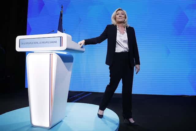 Marine Le Pen stepping down from the podium after giving a pre-election speech. 
