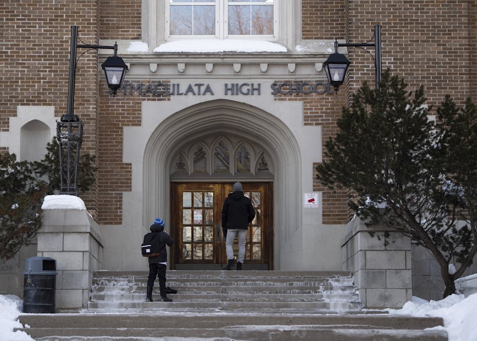 Students seen walking up steps to a high school.