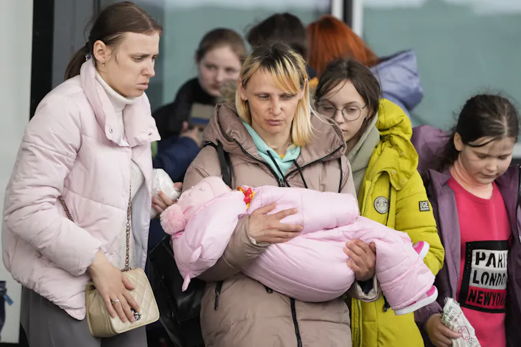Un groupe de fillettes et de femmes, dont l’une tient un bébé dans les bras
