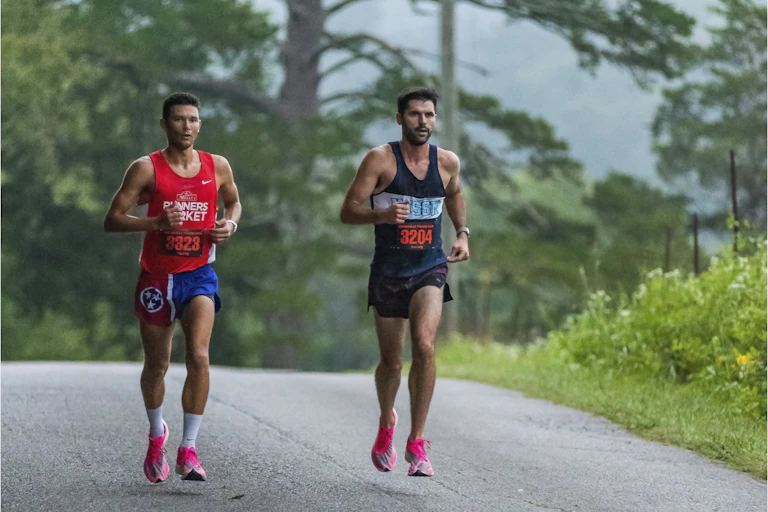 two male runners run a marathon