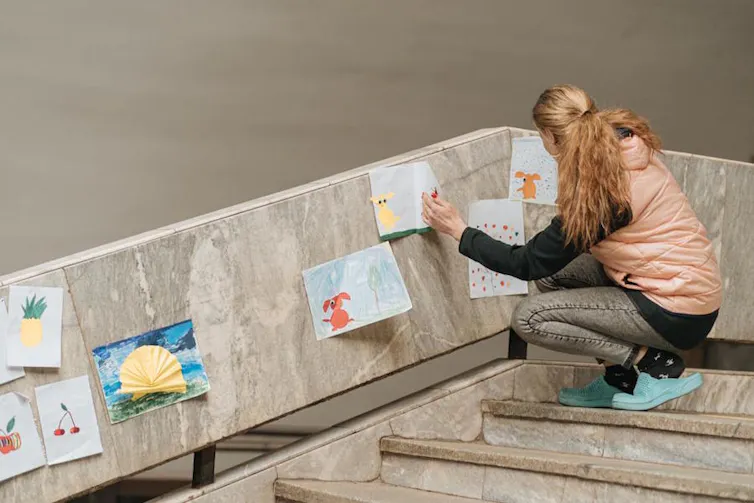 Une femme décore un escalier de la station de métro de Kharkiv avec des dessins d’enfants