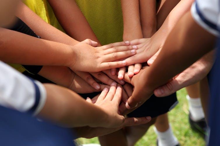 People putting their hands together in a circle