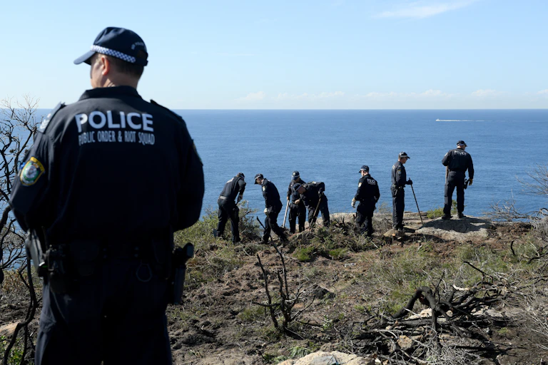 police on the edge of a cliff, conducting a search
