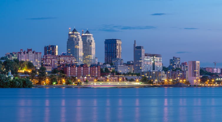 Panorama of the Dnipro skyline showing the Dnieper river and the city's skyscrapers.