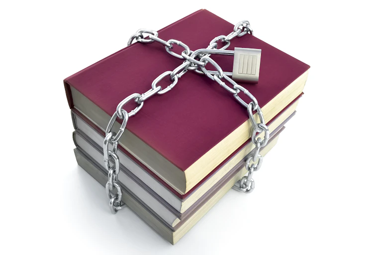 Four books, held together with a chain and a lock on the chain.