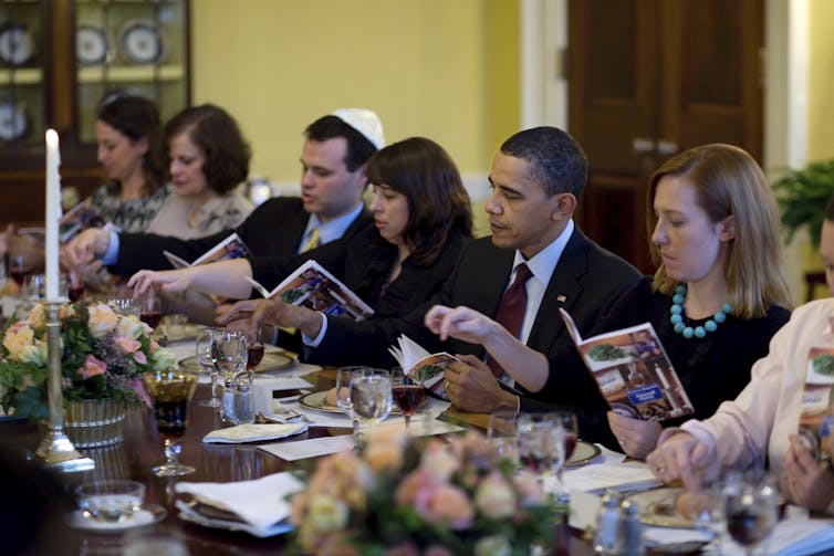 President Obama and guests sit around a dinner table at the White House.