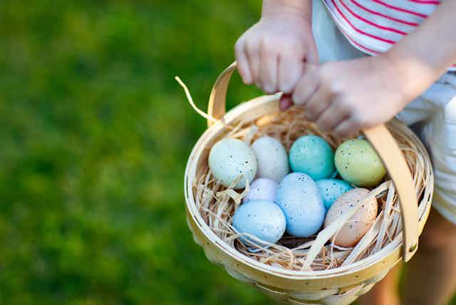Child holding basket of Easter eggs