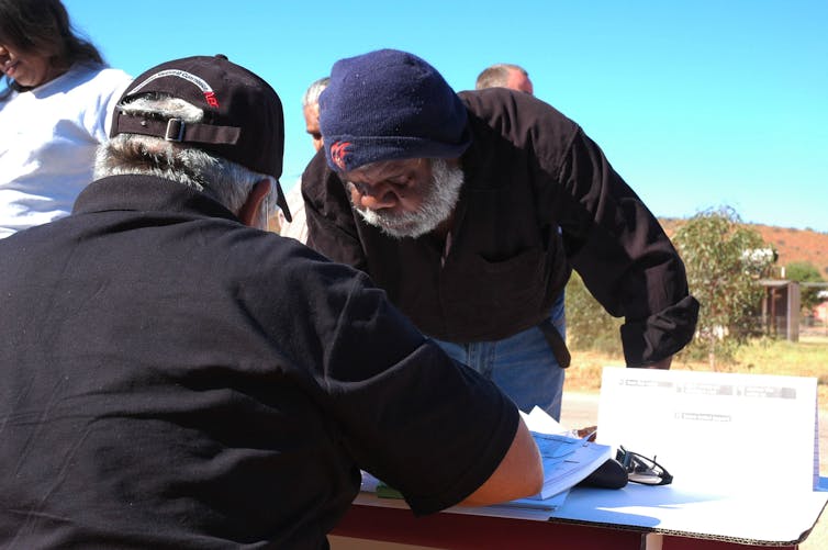 A First Nations person is casting their vote in an election.