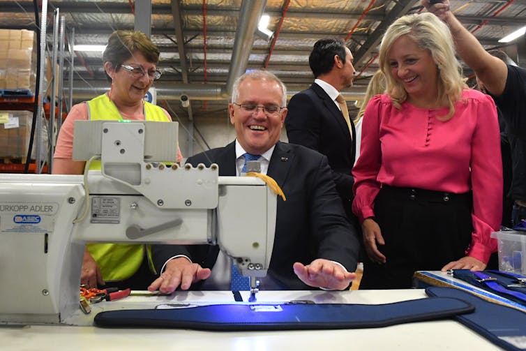 Scott Morrison with a machine at a factor.