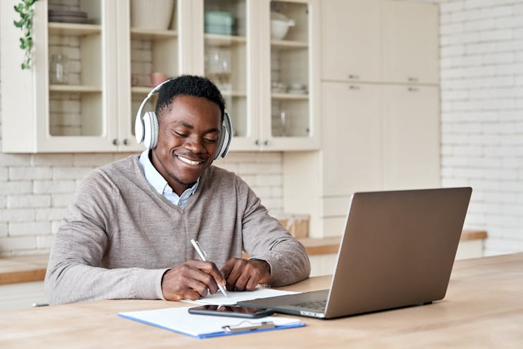 Man taking notes at laptop