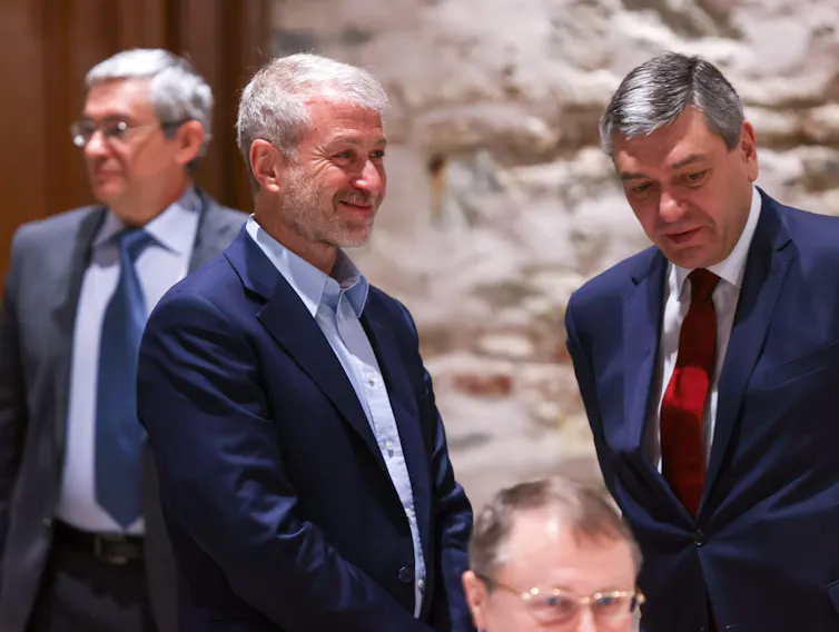 Three men in blue suits stand