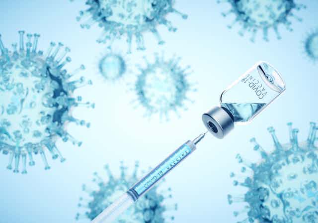 Digitally generated image of syringe filling of COVID-19 vaccine from bottle against viruses on blue background.