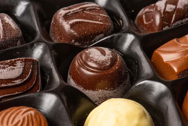 Chocolate pieces in tray with a white film of bloom on them