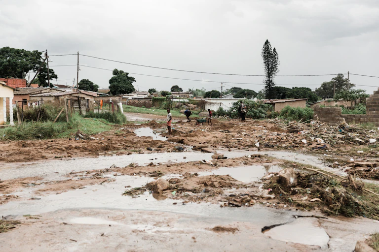 A muddy landscape dotted with debris and the remains of homes