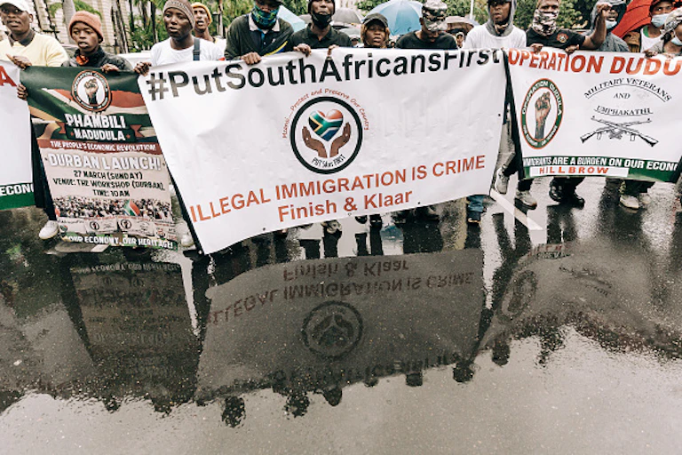 Protesters carry banner saying: 'illegal migration is a crime'.