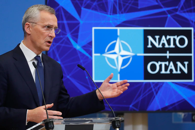 Nato chief Jens Stoltenberg with the Nato logo