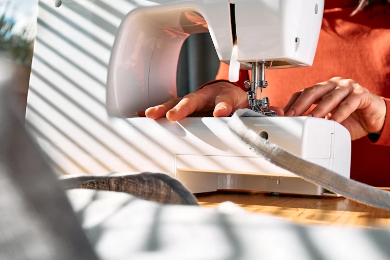 A person works at a sewing machine.