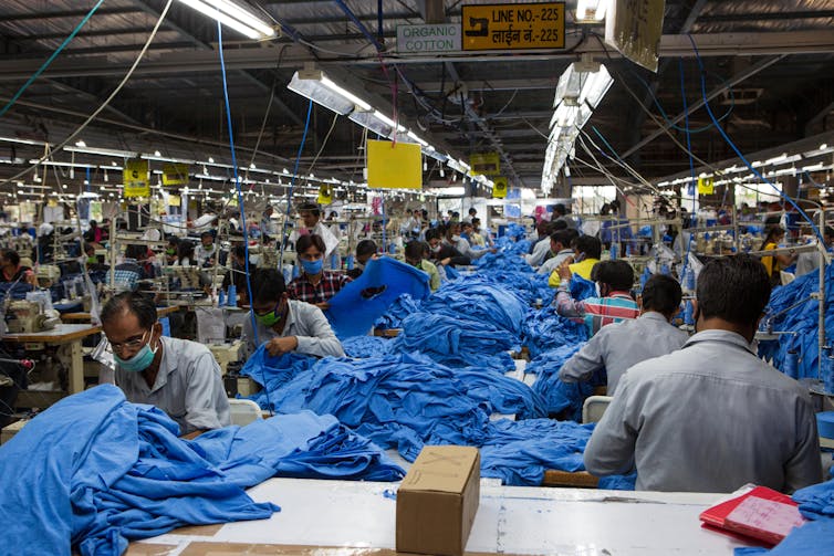 A view along the length of a production line loaded with blue fabric.