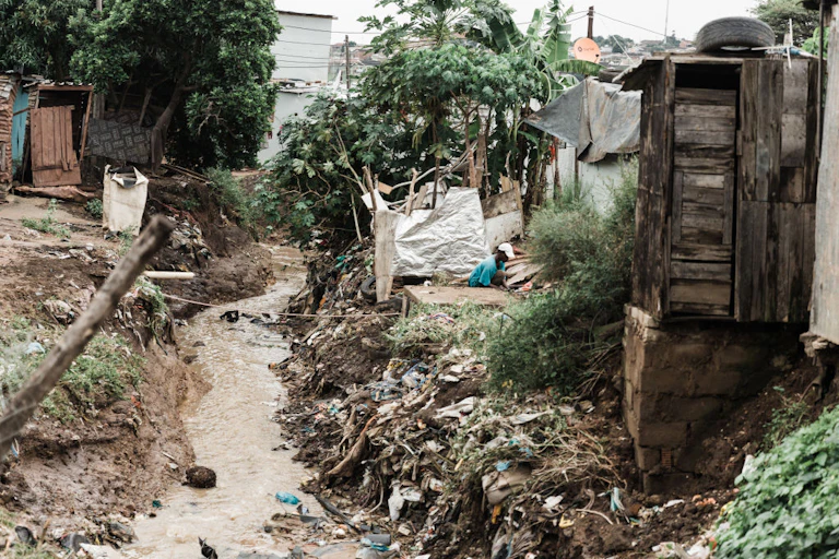 damaged settlements and thin body of water with dirt strewn all over.