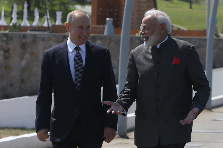 Vladimir Putin and Narendra Modi chat as they walk in the sunshine.