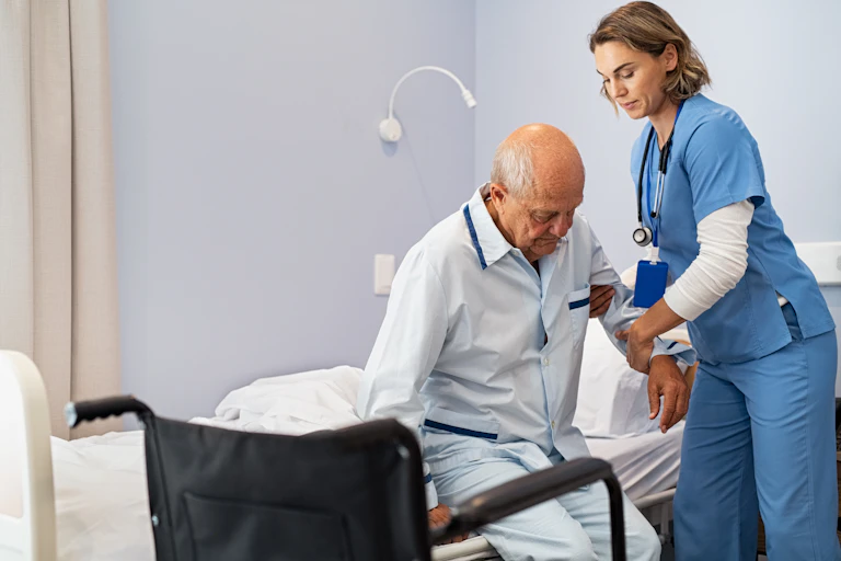 Un vieil homme est assisté par une infirmière.
