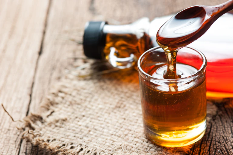 sirop d'érable dans une bouteille en verre sur une table en bois