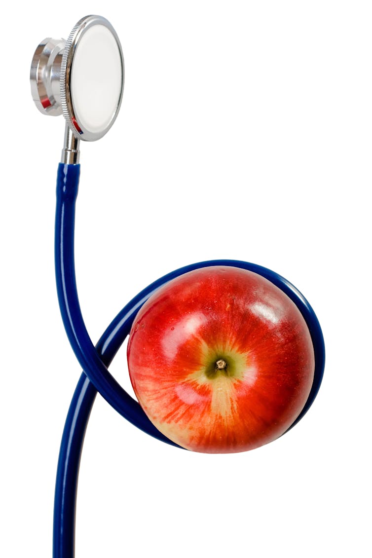 A stethoscope wrapped around an apple.