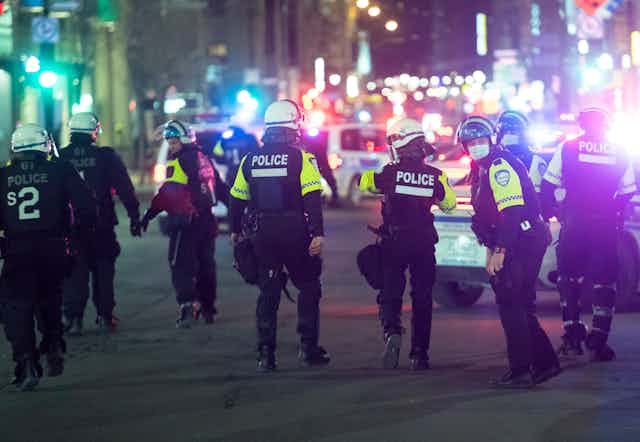 Des policiers déambulent dans une rue d'un centre-ville
