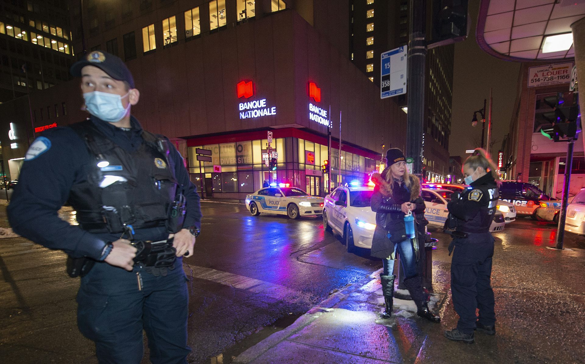 Une femme est interpellée par deux policiers sur une rue du centre-ville