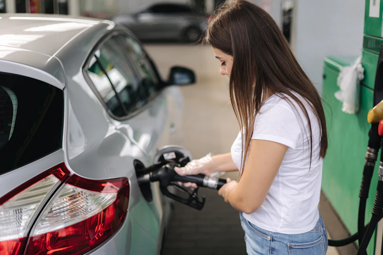 Mujer llenando el depósito de su vehículo.