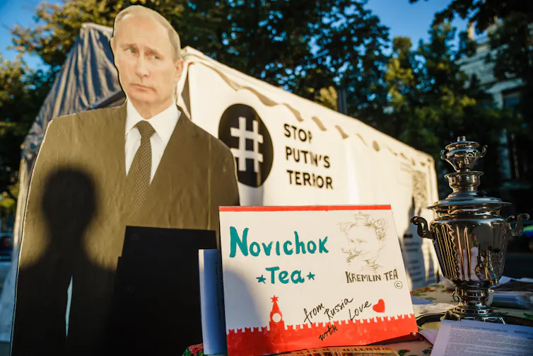 Posters showing Russian President Vladimir Putin and a teapot, with text reading 'Stop Putin's Terror' and 'Novichok Tea'