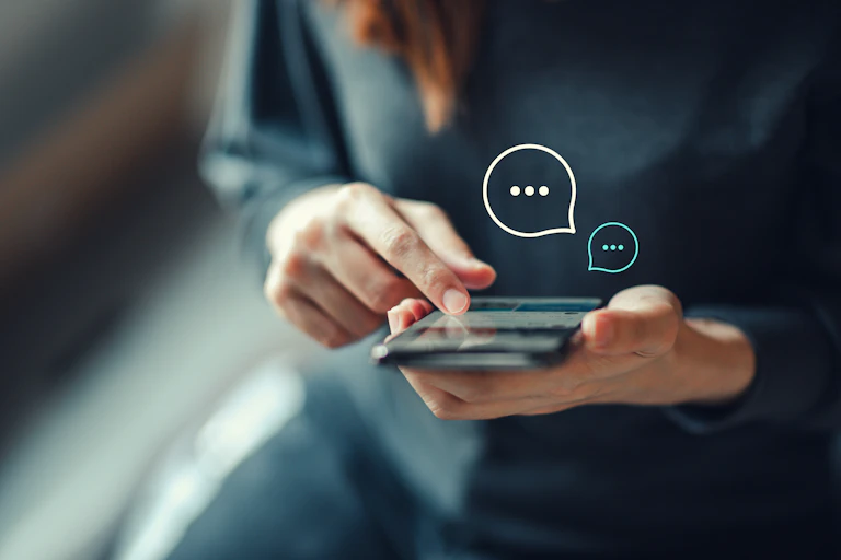A woman looking at a messenging app on her mobile phone