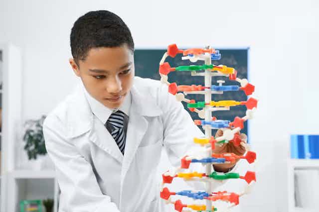 Anak laki-laki melihat model DNA