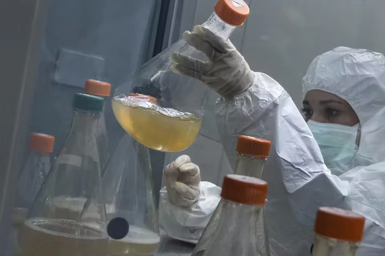 Scientist picking up conical flask