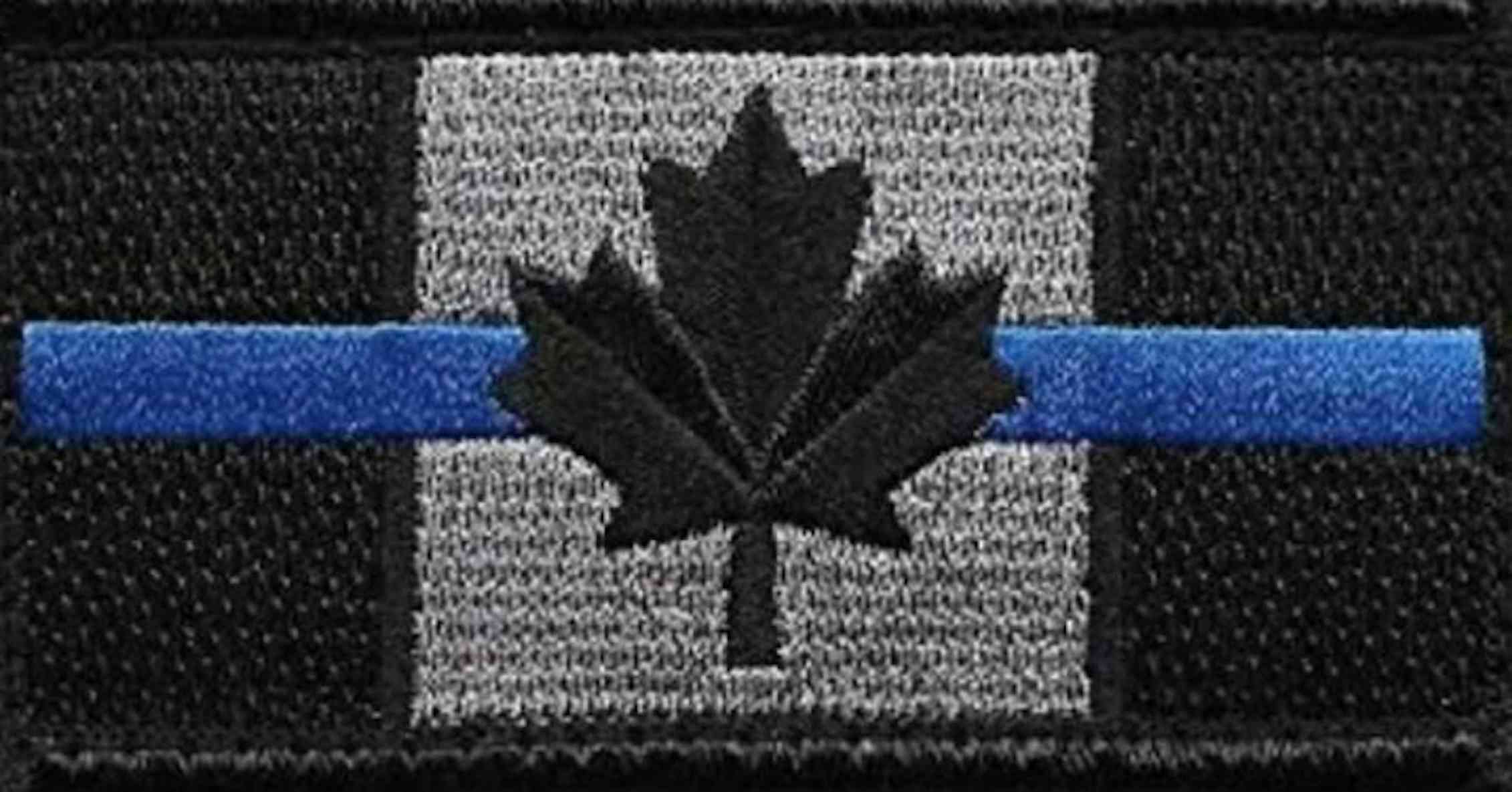 A cloth badge: Black and white Canadian flag with a horizontal thin blue line through it.