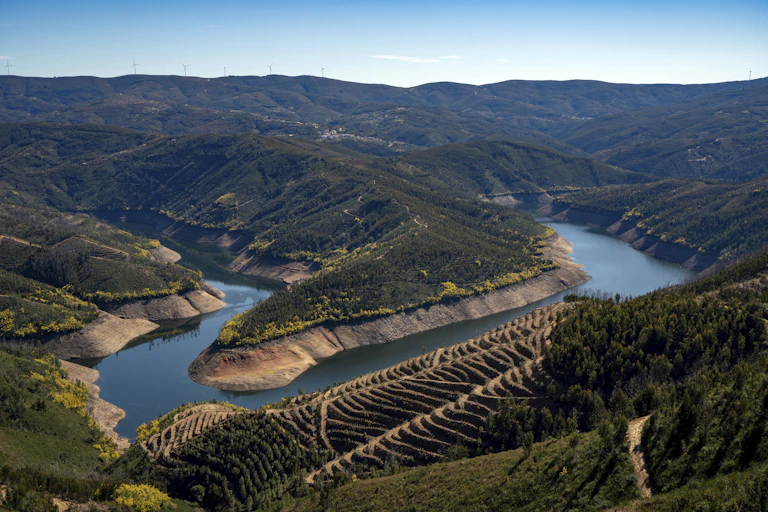 A river bend with water levels well below normal, and terraced agricultural field in the foreground.