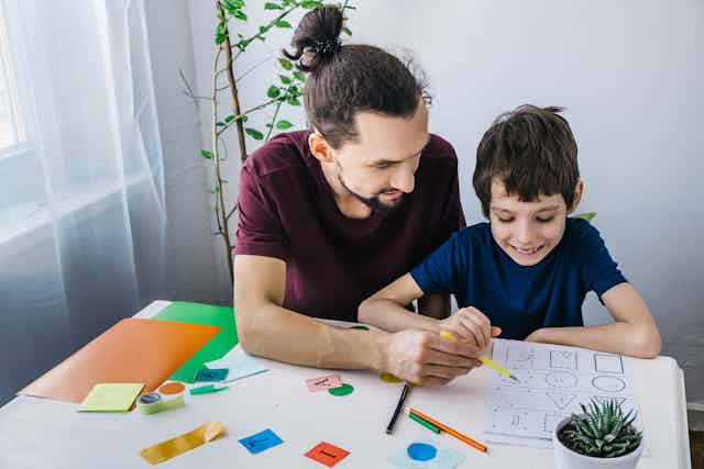 Man and young boy doing colouring