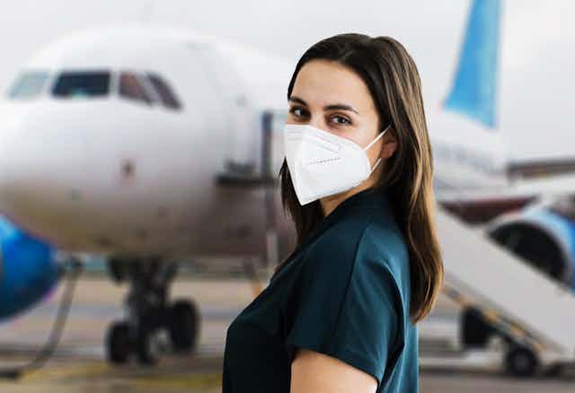 Woman wearing mask about to board plane