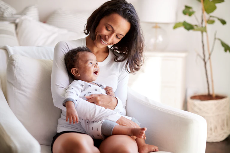 A mother with a baby on a couch.