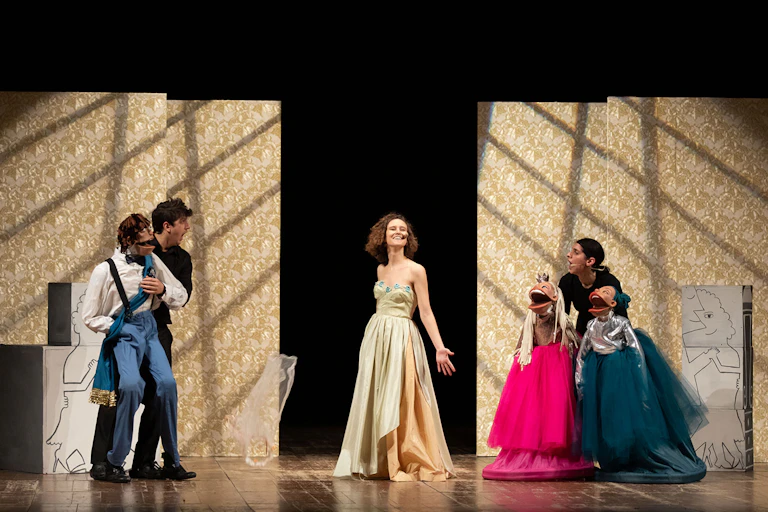 Cantantes y marionetas sobre un escenario.