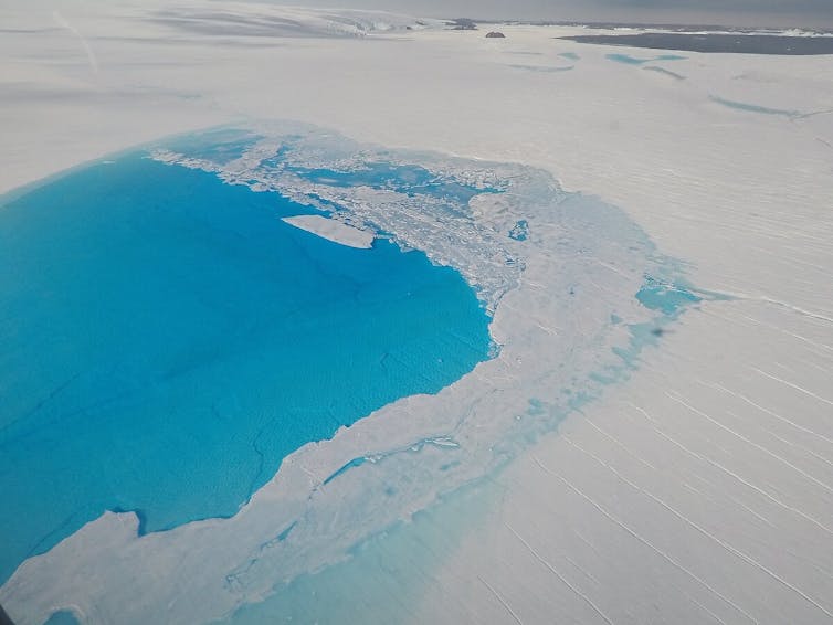 A bright blue lake on an ice shelf