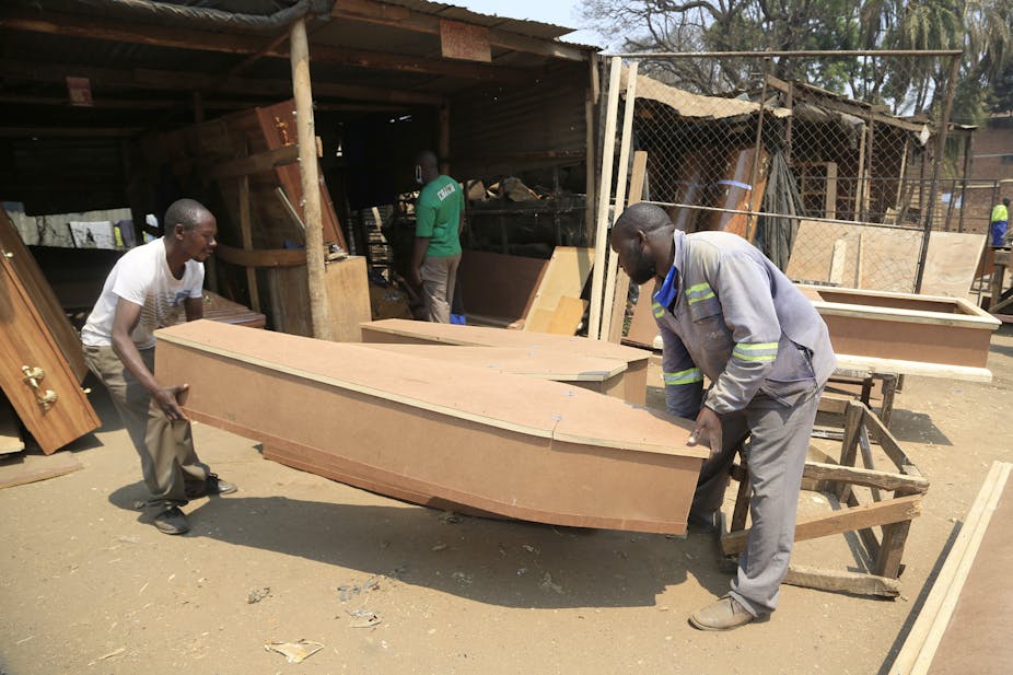 Two men carry a coffin inside a street stall