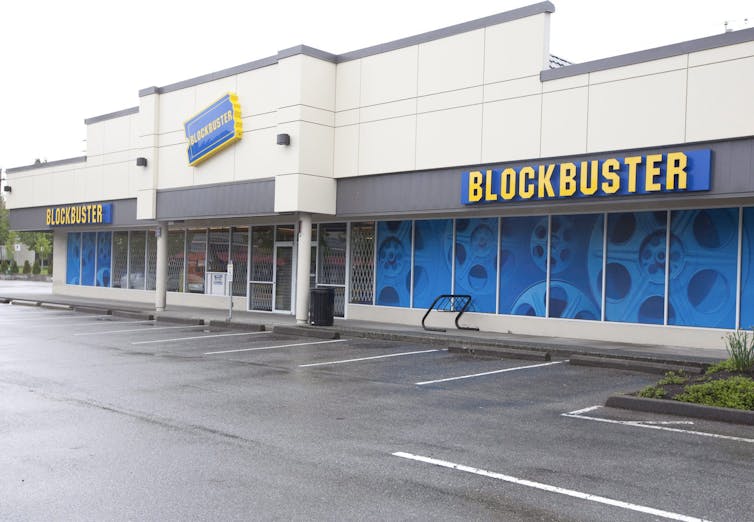 A building in an empty parking lot that says BLOCKBUSTER across the front