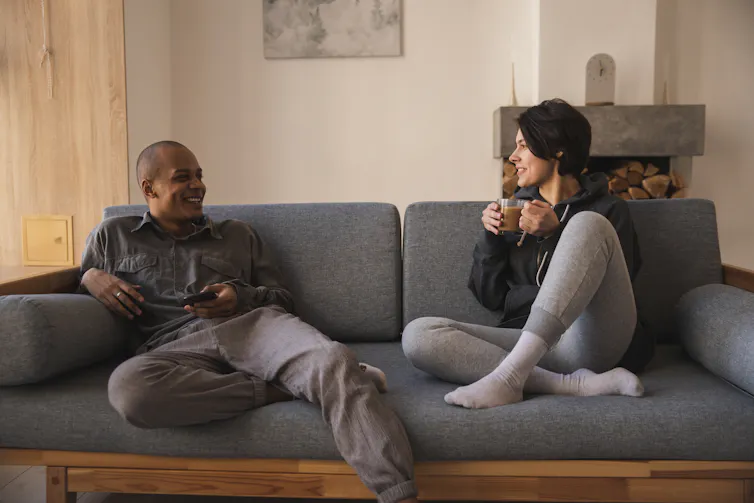 A man and a woman relaxing on a sofa talking