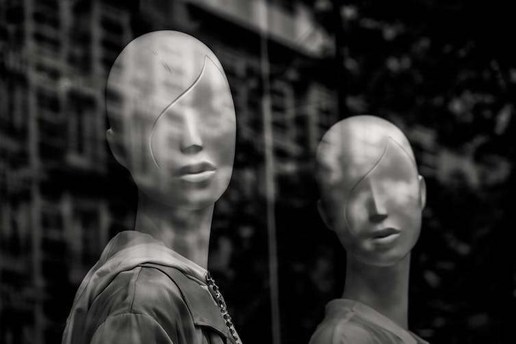 Two female manikins in a window.