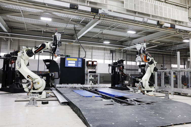 Two huge robotic arms sitting in a large, empty garage