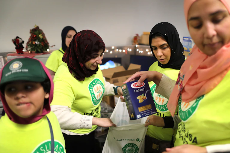 Muslim volunteers assemble bags of food to give away.