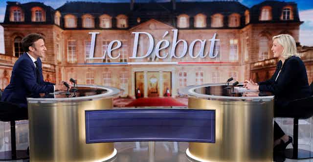 Emmanuel Macron and Marine Le Pen sitting across from one another during a TV debate. 