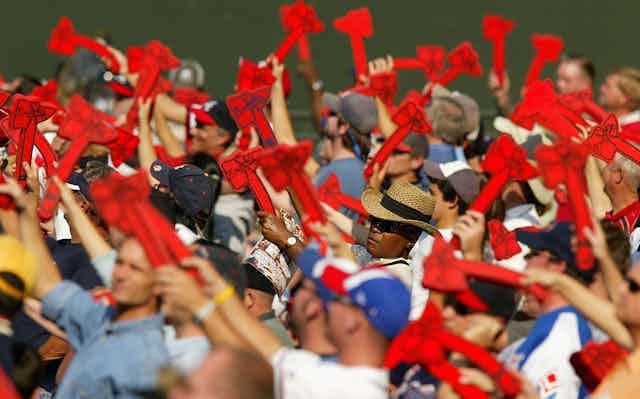 Baseball fans wave red foam tomahawks.