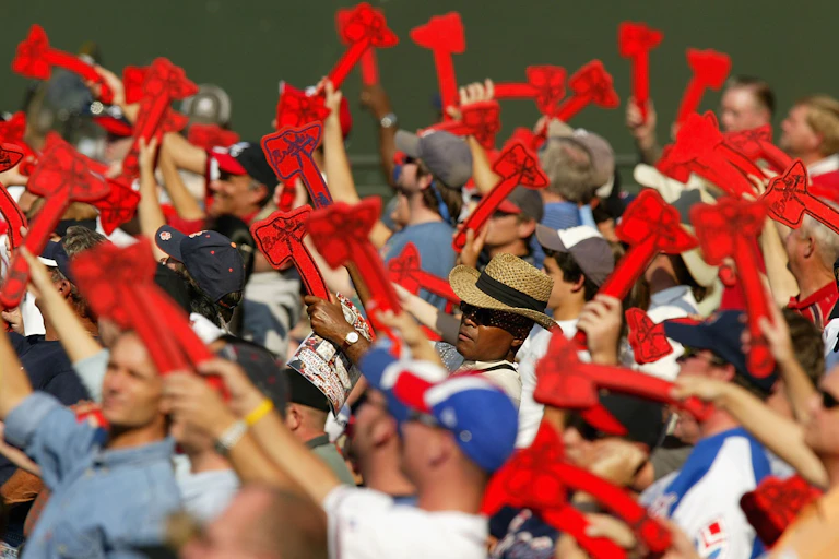 Baseball fans wave red foam tomahawks.